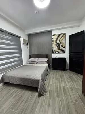 a bedroom with a bed and a television in it at Condo in Malate in Manila