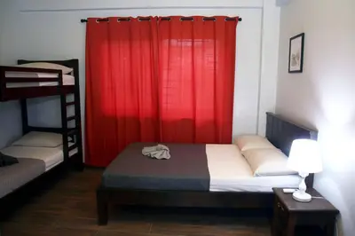 a bedroom with two bunk beds and a red curtain at Villa Ariana Family Getaway in Bukal