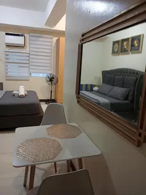 a living room with a mirror and a couch at Newport 101 - East Wing in Manila