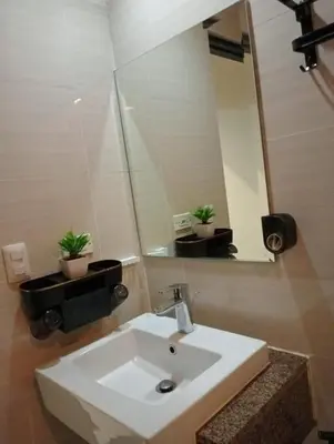 a bathroom with a white sink and a mirror at Newport 101 - East Wing in Manila