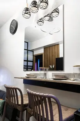 a dining room with two chairs and a mirror at Comfortable 2-Bedroom Home in Paranaque in Manila