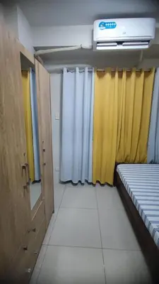 a room with yellow and white curtains and a bed at Shell Residences in Manila