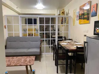 a dining room with a table and a couch at Shore Residences C1 in Manila