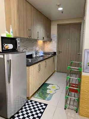 a kitchen with a refrigerator and a counter top at Shore Residences C1 in Manila