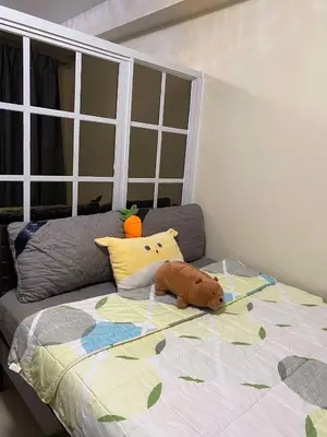 a stuffed animal laying on a bed in a bedroom at Shore Residences C1 in Manila