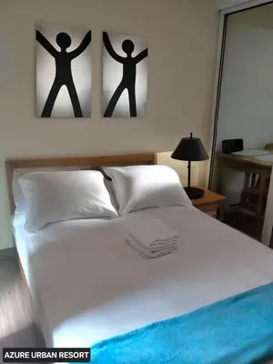 a bedroom with a bed with two pictures on the wall at Azure Urban Resort Staycation By J&R in Manila