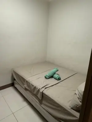 a small bed in a room with a blue pillow at 2 bedroom Haven in Manila