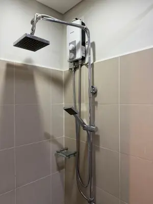 a shower in a bathroom with a shower head at 2 bedroom Haven in Manila