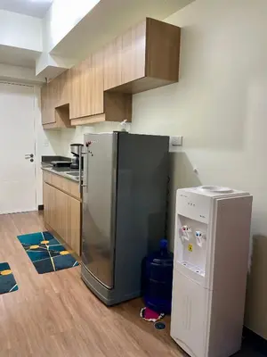a kitchen with a stainless steel refrigerator and cabinets at Satori Residences in Manila