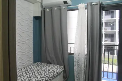a bedroom with a bed and curtains and a window at Shore 2 Residence Tower 2 in Manila