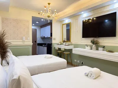 a hotel room with two beds and a flat screen tv at Homefort Twin Bed Suite - Red Residences Makati 1146 in Manila