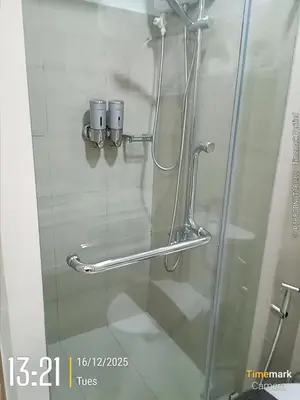 a shower with a glass door with two cups at Homefort Twin Bed Suite - Red Residences Makati 1146 in Manila