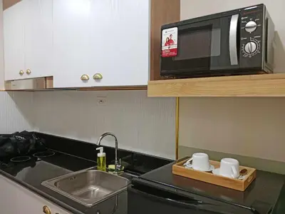 a kitchen with a sink and a microwave at Homefort Twin Bed Suite - Red Residences Makati 2202 in Manila