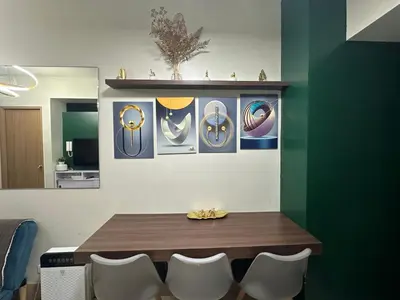 a dining room with a table and some pictures on the wall at Modern and Cozy Suite at Shore Residences in Manila