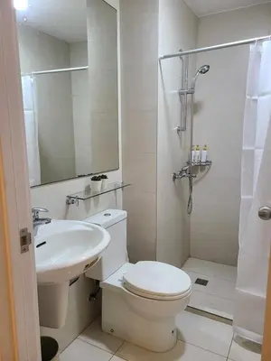 a bathroom with a toilet and a sink and a shower at Staycation in Mandaluyong near Makati and BGC in Manila