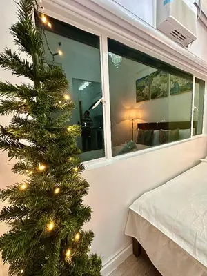 a christmas tree in a room with a window at Studio Two Condominium, Alabang - GOLD FIBER WI-FI -NETFLIX READY in Manila
