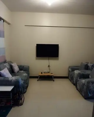 a living room with two couches and a flat screen tv at Life in refinement at Ivory Wood in Manila