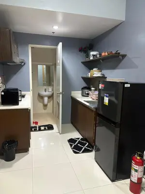 a kitchen with a black refrigerator and a toilet at FamilyRoom 1 bedroom in Manila