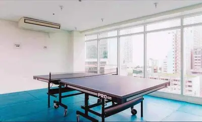 a ping pong table in a room with a large window at Birch Tower Malate Manila by T&T in Manila
