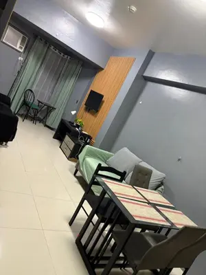 a living room with a couch and a table and chairs at Family budget room, infront US of Embassy in Manila