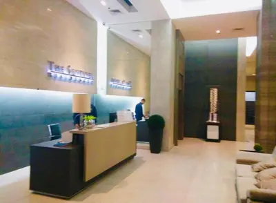 a man standing at a counter in a lobby at Pent House for Your Staycation in Manila