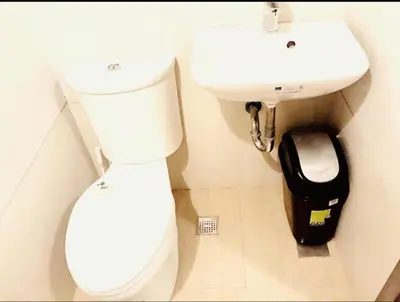 a bathroom with a white toilet and a sink at Pent House for Your Staycation in Manila