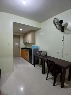 a kitchen with a wooden table and a tableablish at Breeze Residences in Manila