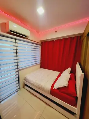 a bedroom with a bed with a red curtain at Mavic Staycation in Manila