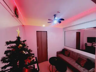 a living room with a christmas tree and a ceiling fan at Mavic Staycation in Manila