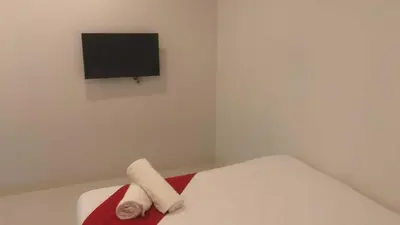 a white room with a bed with a tv on the wall at OYO 1128 HOTEL SANGCO in Manila
