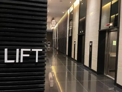 a hallway in a building with a lift sign on the wall at Destina at Air Residence Makati, MetroManila, Netflx in Manila
