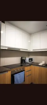 a kitchen with white cabinets and a blue towel at One winstar realty corp in Manila