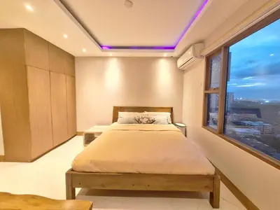 a bedroom with a bed and a large window at STAYLUXIA BOUTIQUE HOTEL MANILABAYVIEW - 1-5 BR Luxury and Superior Condos with, Balcony, Pool, Netflix & Gym- Housekeeping Available - in Manila