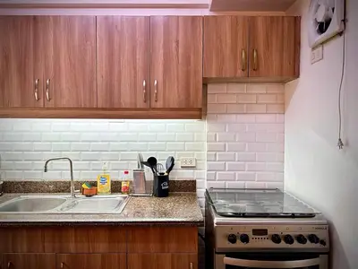 a kitchen with a sink and a stove at The Cozysweet Homestay in Manila