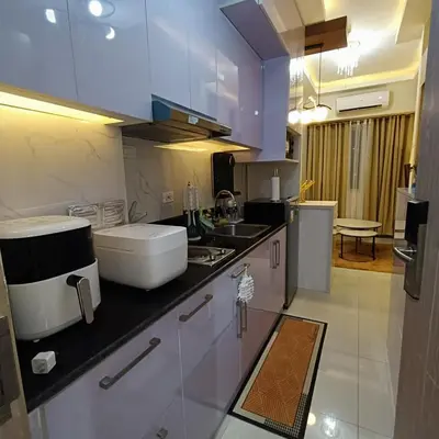 a kitchen with white cabinets and a counter top at Field Residence Cozy Condo In Paranaque in Manila