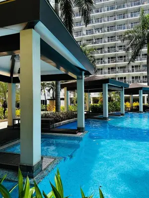a swimming pool in front of a large building at 1232A Near MOA and Airport Pool View Balcony in Manila