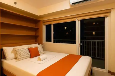 a bed in a room with a large window at 729A Near MOA and Airport PoolView Balcony in Manila