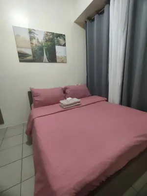 a bedroom with a pink bed with a pink blanket at Gaby's Condotel in Manila