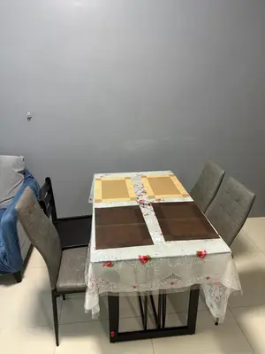 a table with two chairs and a table with a quilt on it at Family Budget Room in Manila