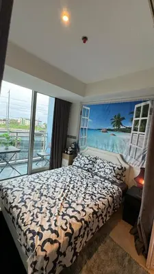 a bedroom with a bed with a view of the ocean at Jules Cozy StayCay II in Manila