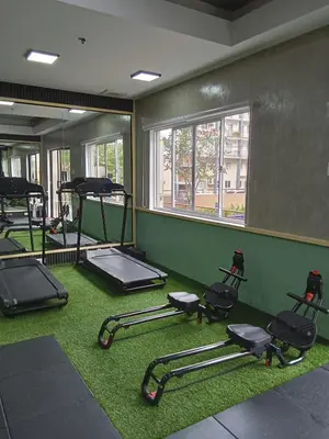 a gym with a bunch of exercise equipment on the floor at Cali Suite - Nuvali in Pitland