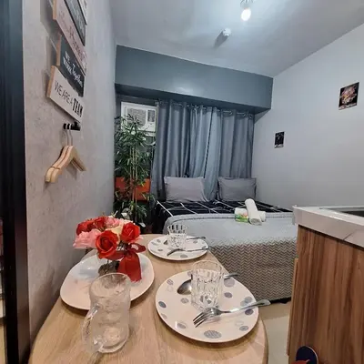 a room with a bed and a table with plates and glasses at G and A CONDOTELS in Manila
