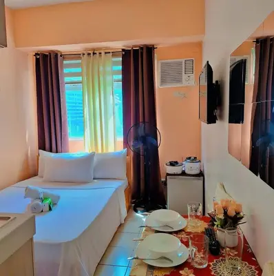 a small room with a bed and a table at G and A CONDOTELS in Manila