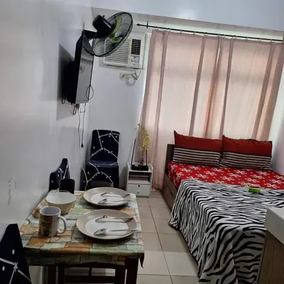 a room with a bed and a table with plates on it at G and A CONDOTELS in Manila