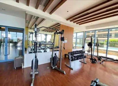 a gym with several treadmills and machines in a room at Cozy Studio typeunit in Manila