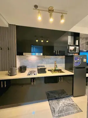 a kitchen with a counter with a sink and a refrigerator at Château Zen&Kat in Manila