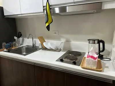 a kitchen counter with a sink and a stove at A King-size bed at Air Residences Condo, Ayala Ave, Makati in Manila