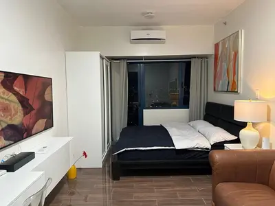 a bedroom with a bed with a window and a couch at Suite at Air Residences Condo, Ayala Ave Makati in Manila