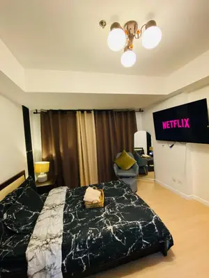 a hotel room with a bed and a sign on the wall at Azure Staycation PH in Manila