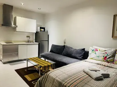 a kitchen and a living room with a bed and a couch at Gramercy Residences Studio With Balcony City View in Manila